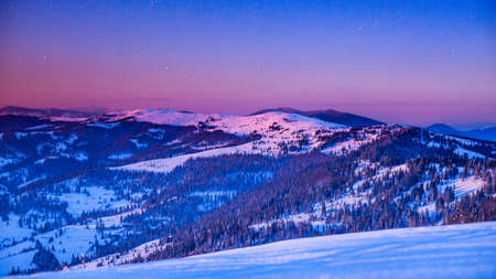 Fog moving over the mountain in winter with a star-shaped skyの写真素材
