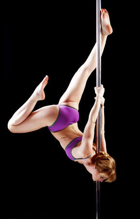 The strong and graceful young girl performing acrobatic exercises on pylonの写真素材