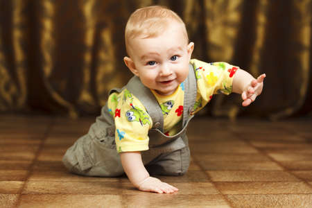 Childhood. Portrait of crawling baby boy on the bed curiously looking behind the cameraの写真素材