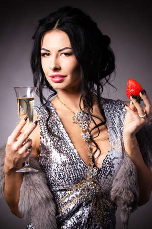 Portrait of a brunette beauty with honey dripping strawberry.の写真素材