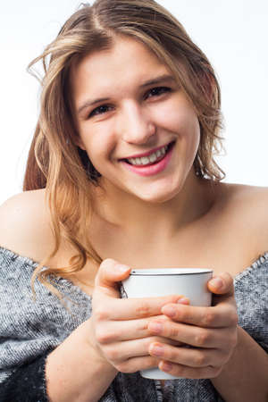 A woman in a bathrobe holds a mug of water. The woman drinks a lot of water. She drank a lot and stayed at home. close-up. isolated.の写真素材