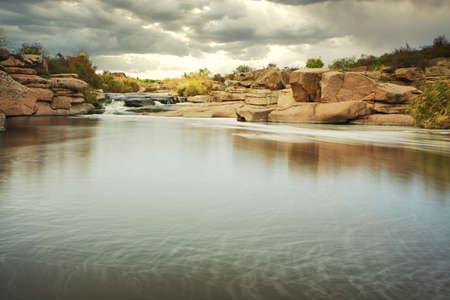 Beautiful mountain river flowing over rocks. Flow of water in mountain river close upの写真素材