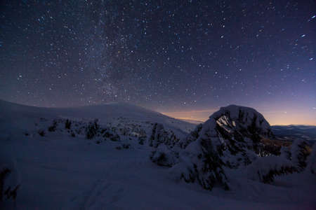 Fantastic starry sky. Winter landscape and snow-capped peaks. Carpathian mountains. Ukraine. Europeの写真素材