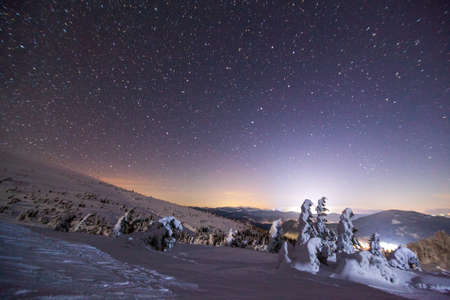 Fantastic starry sky. Winter landscape and snow-capped peaks. Carpathian mountains. Ukraine. Europeの写真素材