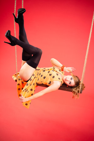 Displeased pin up woman posing with crossed arms on pink backgroundの写真素材