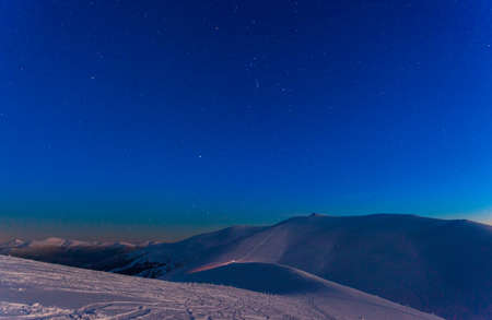 Fantastic starry sky. Winter landscape and snow-capped peaks. Carpathian mountains. Ukraine. Europeの写真素材