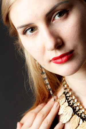 Woman putting on diamond earrings. Caucasian beauty lady trying and shopping jewelry.の写真素材