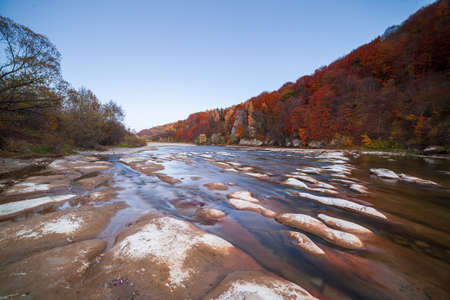 View of the waterfall in autumn. Waterfall in autumn colors. Mountain river in the autumn landscape. Ukraine, river Stryj.の写真素材