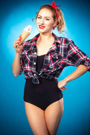 Beautiful pin up stylized young pregnant woman in kitchen drinking juiceの写真素材