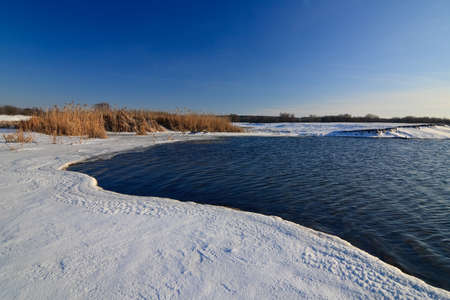 Beautiful winter landscape with frozen lake and sunset sky. Composition of nature.の写真素材
