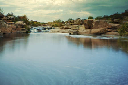 Beautiful mountain river flowing over rocks. Flow of water in mountain river close upの写真素材