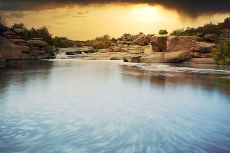 Beautiful mountain river flowing over rocks. Flow of water in mountain river close upの写真素材