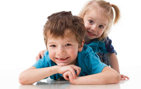 Portrait of a brother and sister, curly blond with blue eyes laughing merrily on a white background. Childrens emotions, happiness, joy, fun. Beautiful cute children. Friendship.の写真素材