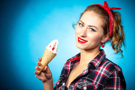 Beautiful pin up stylized young pregnant woman in kitchen drinking juiceの写真素材