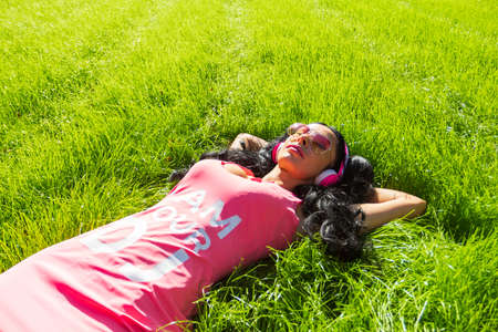 Horizontal portrait of pretty student girl spending day in park and showing thumb up. Cheerful young...