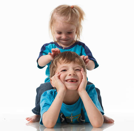 Portrait of a brother and sister, curly blond with blue eyes laughing merrily on a white background. Childrens emotions, happiness, joy, fun. Beautiful cute children. Friendship.の写真素材