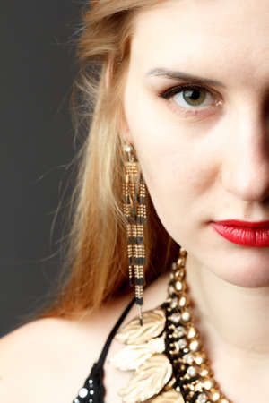 Woman putting on diamond earrings. Caucasian beauty lady trying and shopping jewelry.の写真素材