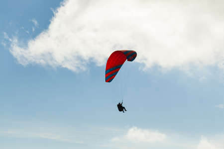Paraglider flying over clouds in summer dayの写真素材