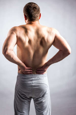 Pain in a body of the man on gray backgroundの写真素材