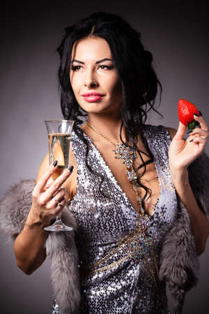 Portrait of a brunette beauty with honey dripping strawberry.の写真素材