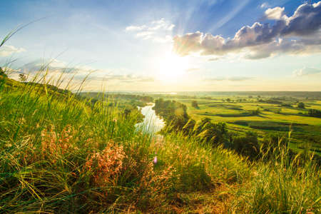 A beautiful valley with a river, blue sky with large clouds and bright sun. Aerialの写真素材