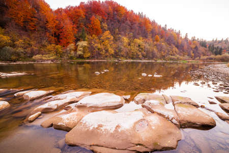 View of the waterfall in autumn. Waterfall in autumn colors. Mountain river in the autumn landscape. Ukraine, river Stryj.の写真素材