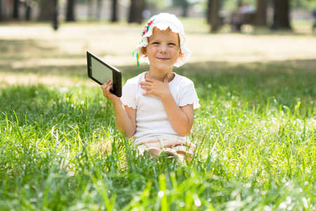 Cute little girl lying on grassの写真素材