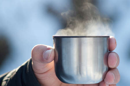 Steaming hot tea from a flask in nature close viewの写真素材
