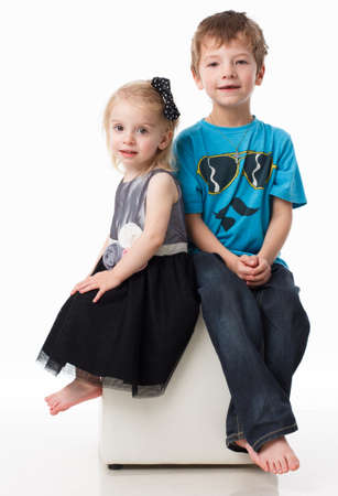 Portrait of a brother and sister, curly blond with blue eyes laughing merrily on a white background. Childrens emotions, happiness, joy, fun. Beautiful cute children. Friendship.の写真素材