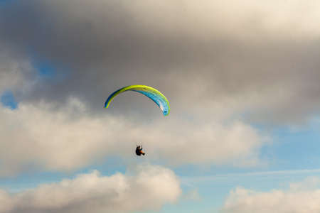 Paraglider flying over clouds in summer dayの写真素材