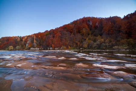 View of the waterfall in autumn. Waterfall in autumn colors. Mountain river in the autumn landscape. Ukraine, river Stryj.の写真素材