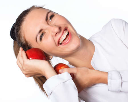 Young happy girl is holding red apple, isolated over whiteの写真素材