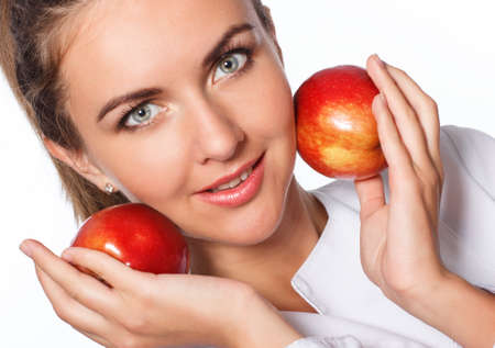 Young happy girl is holding red apple, isolated over whiteの写真素材