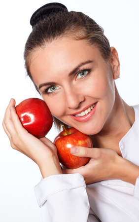 Young happy girl is holding red apple, isolated over whiteの写真素材