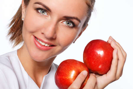 Young happy girl is holding red apple, isolated over whiteの写真素材