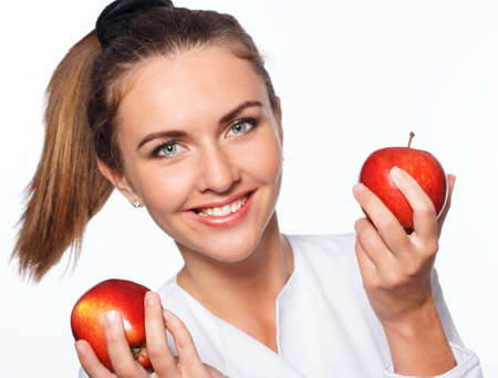 Young happy girl is holding red apple, isolated over whiteの写真素材