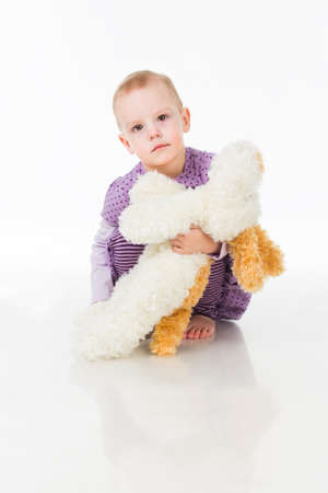 Portrait of a little adorable infant baby girl sitting on the bed and looking to the right side with copyspaceの写真素材