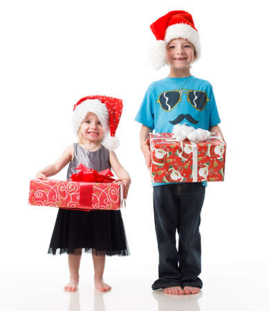 Children charity. school boy and girl in Santa Clause hats. Charity with donate box. Delivery and donation concept. Happy Xmas and New Year holiday. Christmas gifts.の写真素材