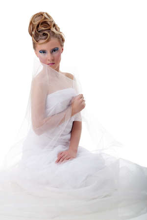 The girl with long hair in a light, white dress posing on light grey background. Studio shot,isolated image.の写真素材