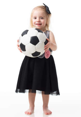 Happy smiling girl teenager wearing casual clothes posing with a football. Active lifestyle. Studio shot. Isolated over white.の写真素材