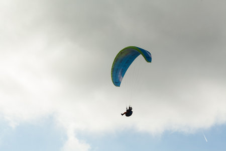 Paraglider flying over clouds in summer dayの写真素材