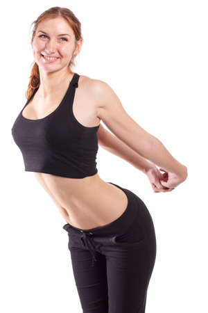 Female fitness model excercising in studio with dunbell weights and doing a floor routine of stretches and lifts on a matt.の写真素材