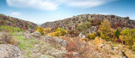 A large number of stone minerals covered with green vegetation lying above a small river in picturesque Ukraine and its beautiful natureの写真素材