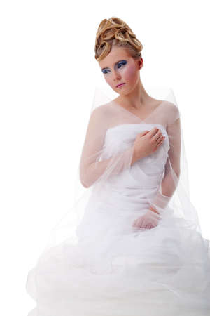 The girl with long hair in a light, white dress posing on light grey background. Studio shot,isolated image.の写真素材