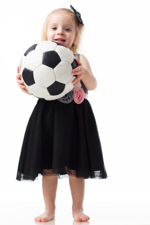 Happy smiling girl teenager wearing casual clothes posing with a football. Active lifestyle. Studio shot. Isolated over white.の写真素材