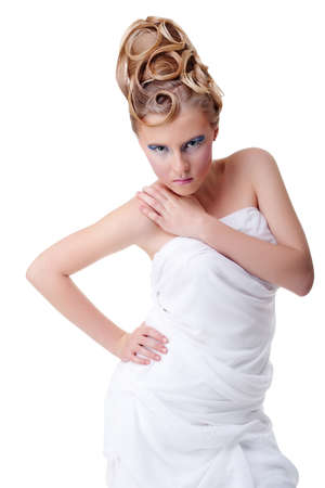 The girl with long hair in a light, white dress posing on light grey background. Studio shot,isolated image.の写真素材