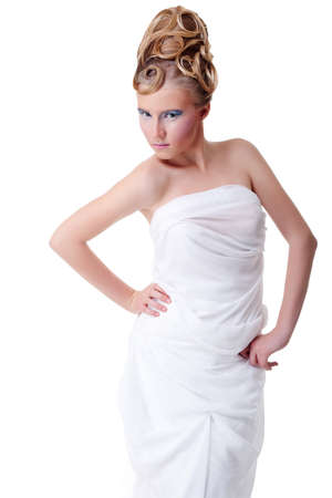 The girl with long hair in a light, white dress posing on light grey background. Studio shot,isolated image.の写真素材