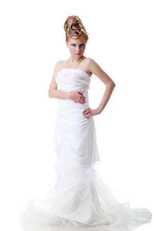 The girl with long hair in a light, white dress posing on light grey background. Studio shot,isolated image.の写真素材