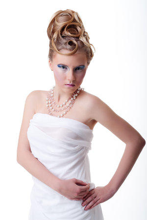 The girl with long hair in a light, white dress posing on light grey background. Studio shot,isolated image.の写真素材