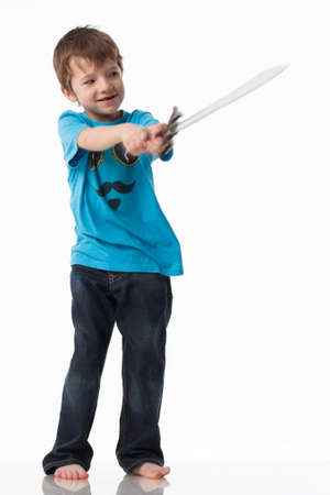 A little boy poses with a sword in a studioの写真素材